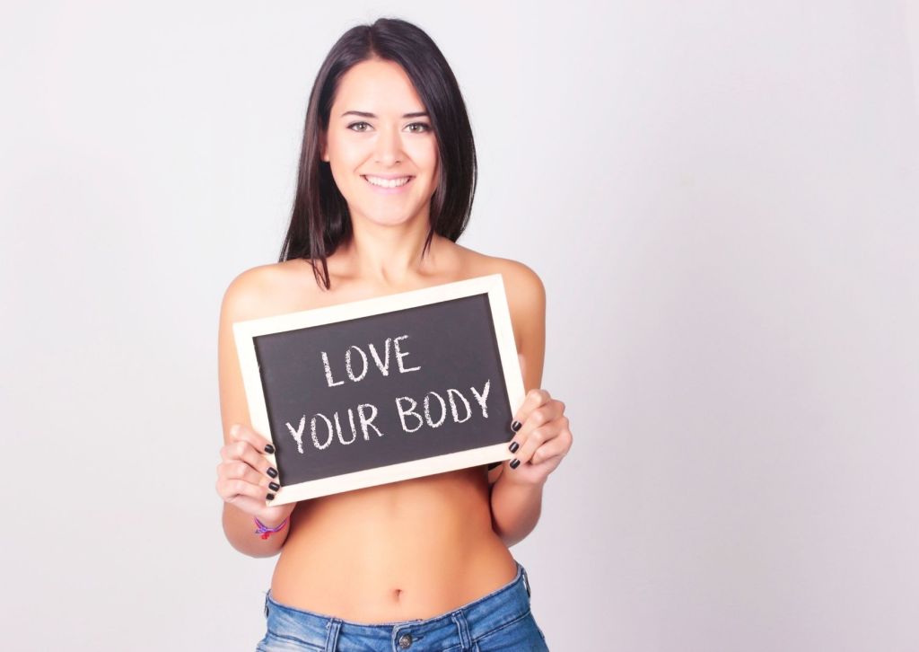 Woman holding a board saying 'Love your body'
